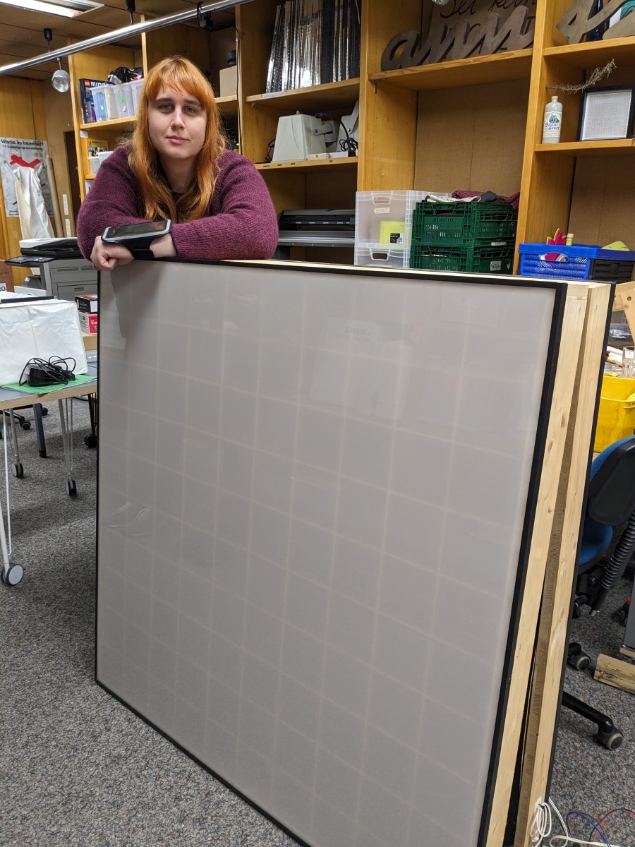 Sophie leans on two wooden LED matrices